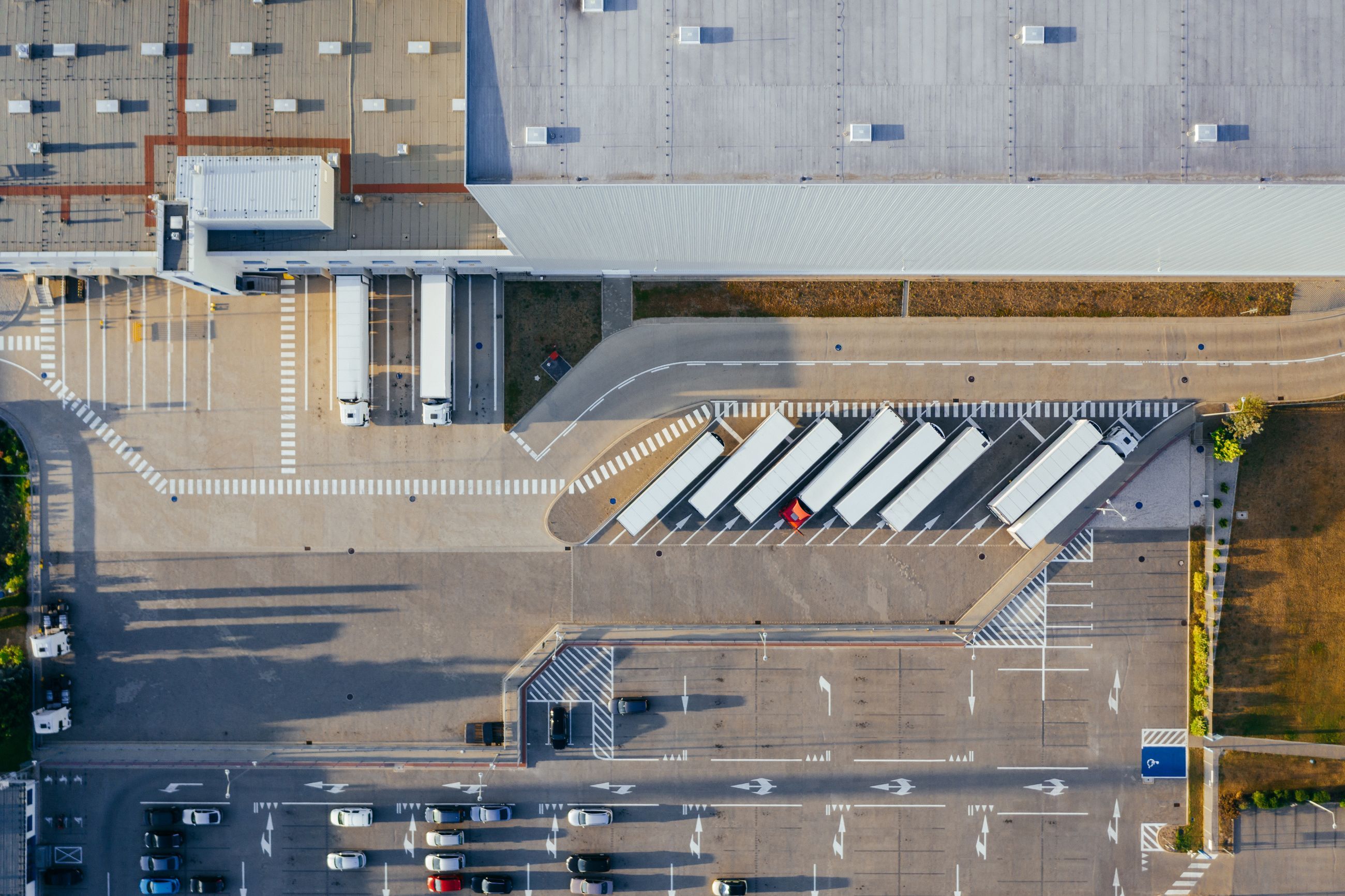 Aerial view of a distribution center with trailers at its dock doors and staged in the yard