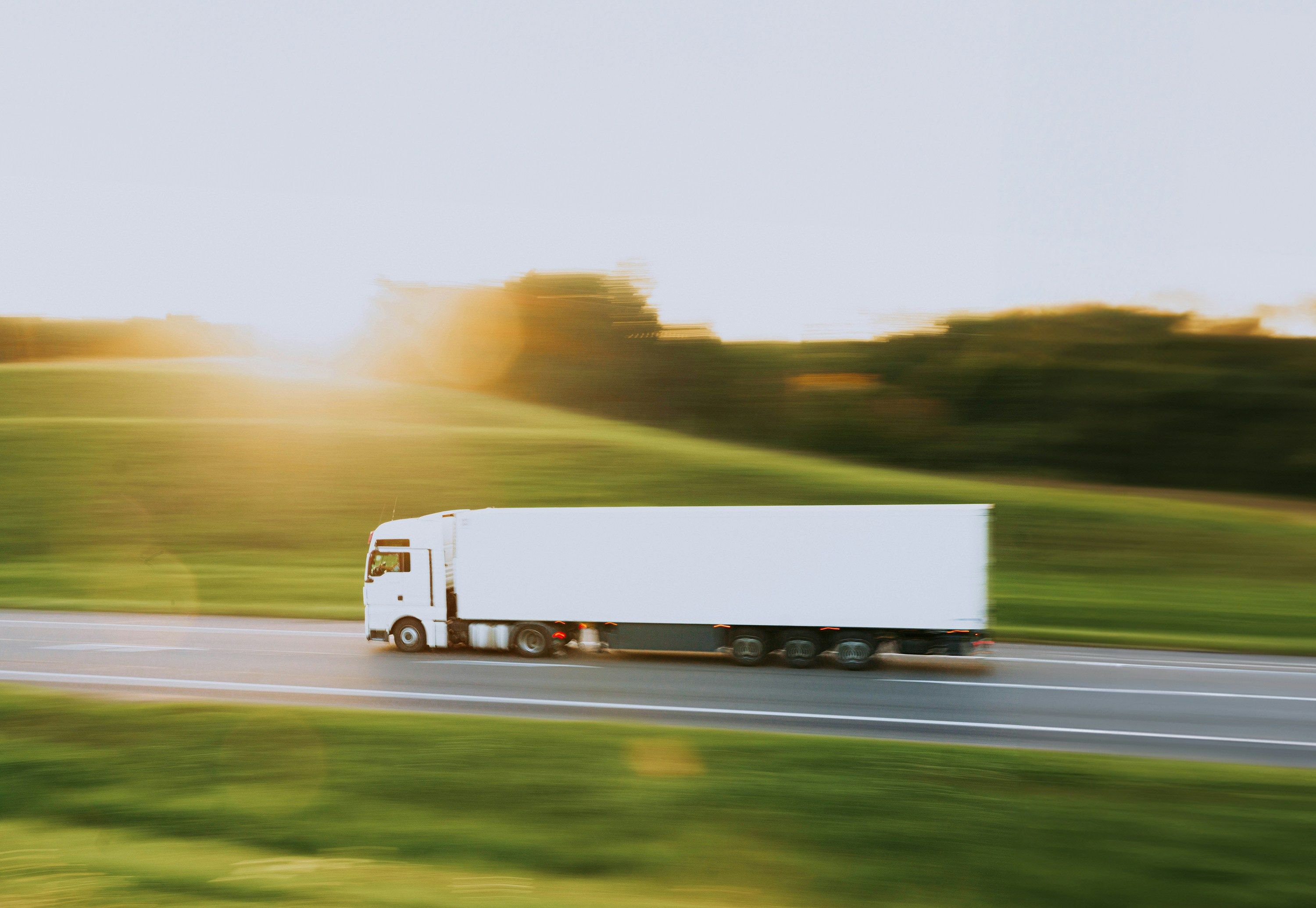 A semi-truck on a highway at sunrise